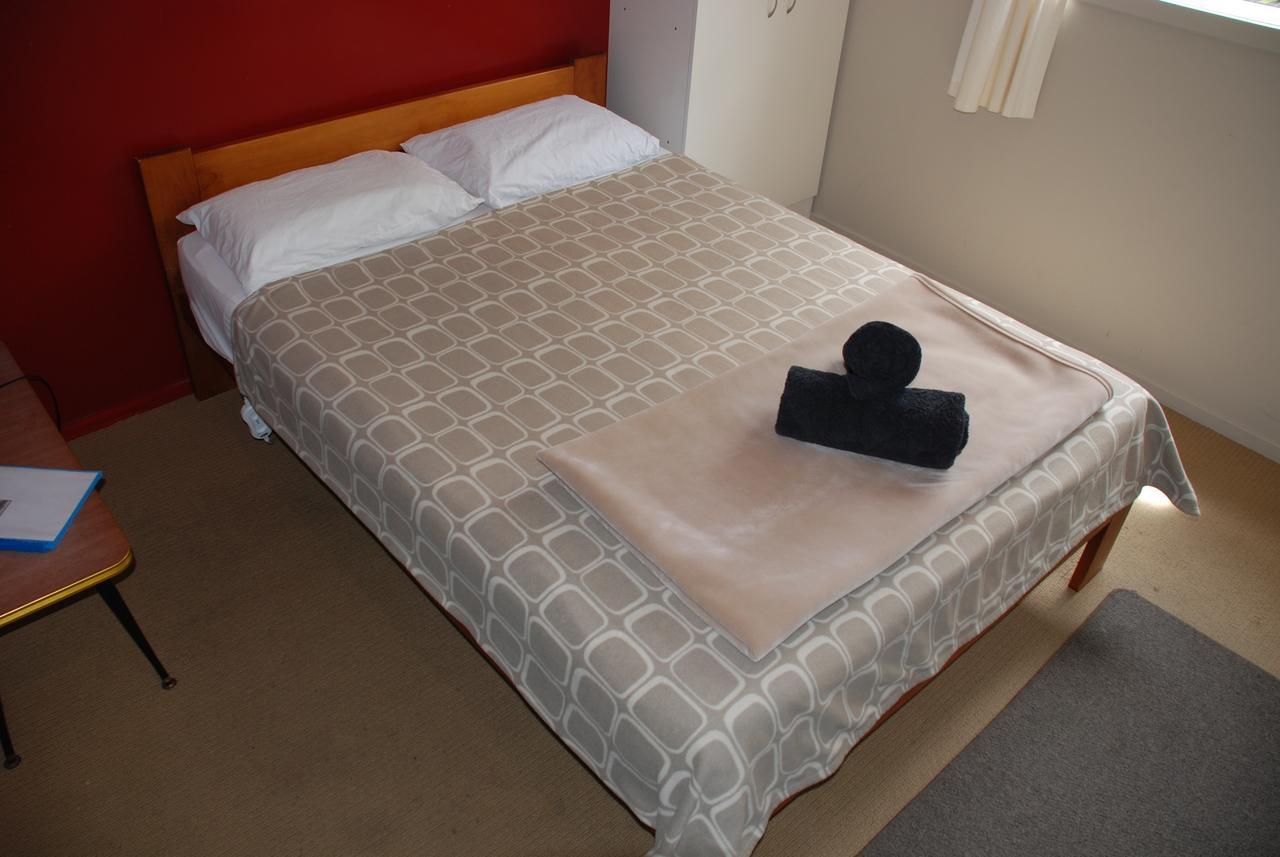 Riverstone Lodge Turangi Exterior foto A bed with a duvet